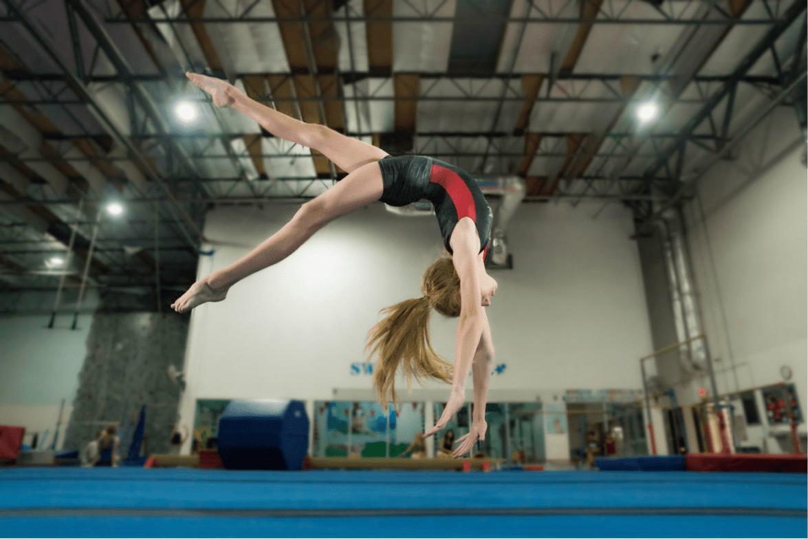 Девушка демонстрирует гимнастическую связку после прыжка на батуте